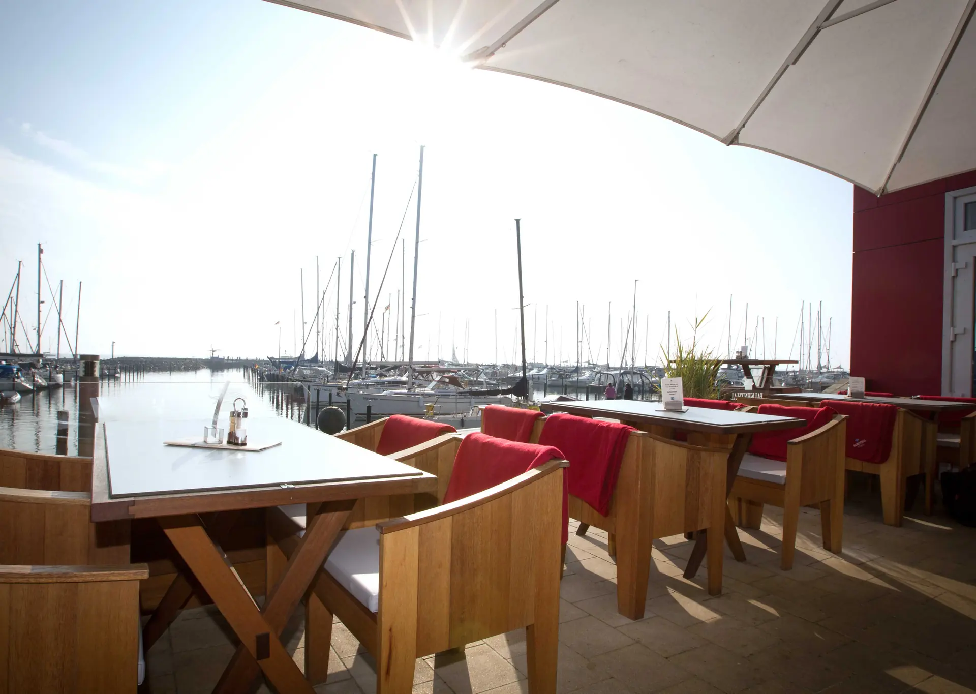Terrasse des Restaurants am Yachthafen mit Blick auf die Segelboote